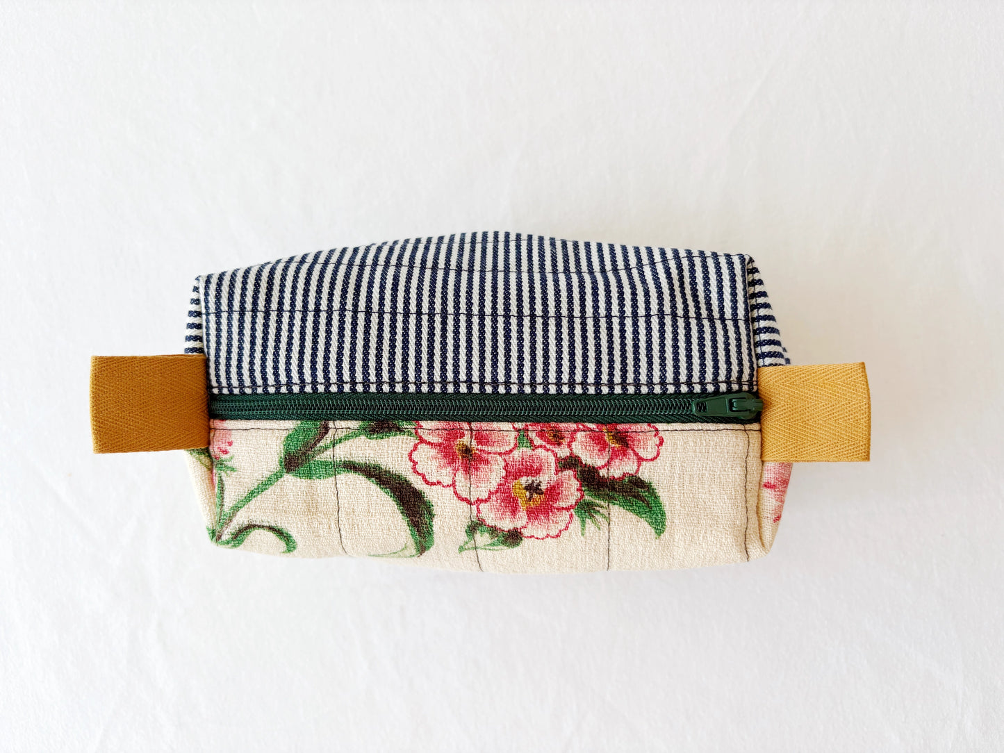 Fabric pouch with floral design and checkered top on a white background